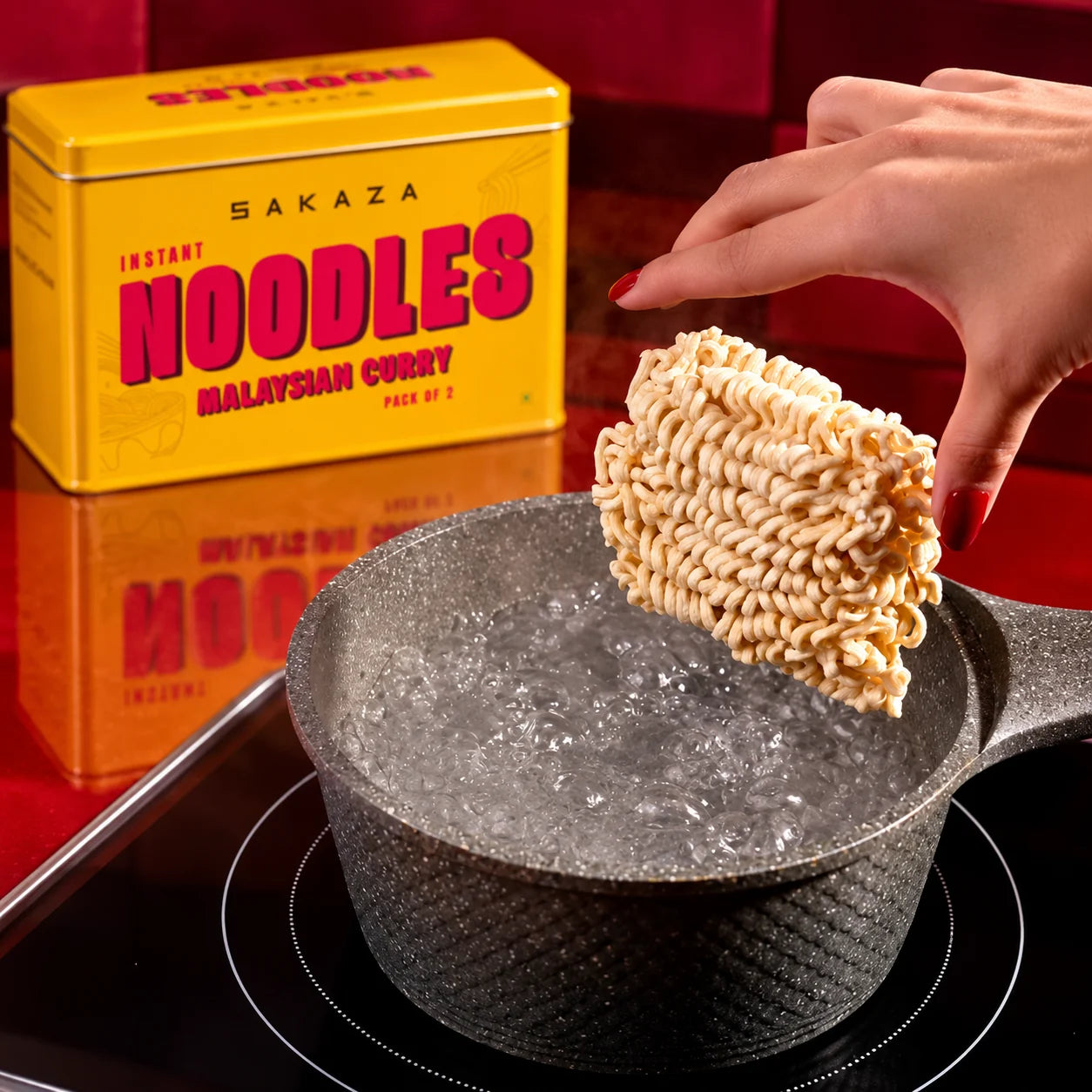Noodle cake being lowered into boiling water